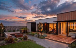 Modern Christchurch property at sunset featuring a fresh lawn, native landscaping, and a sleek pathway made of pavers.