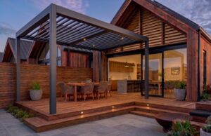 Evening view of a premium timber deck and louvered pergola built by professional landscaping experts.